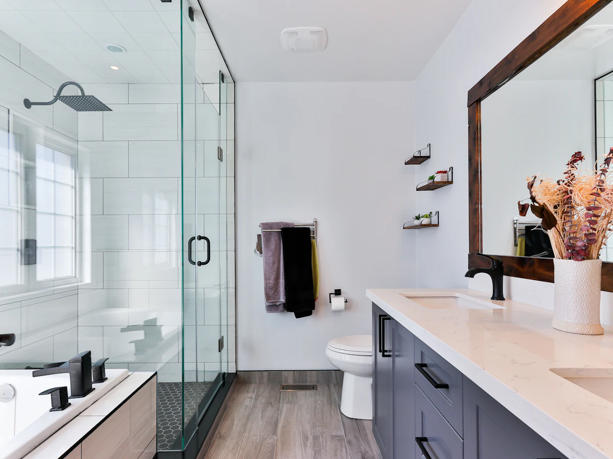 A gleaming modern bathroom with a glass shower and vanity