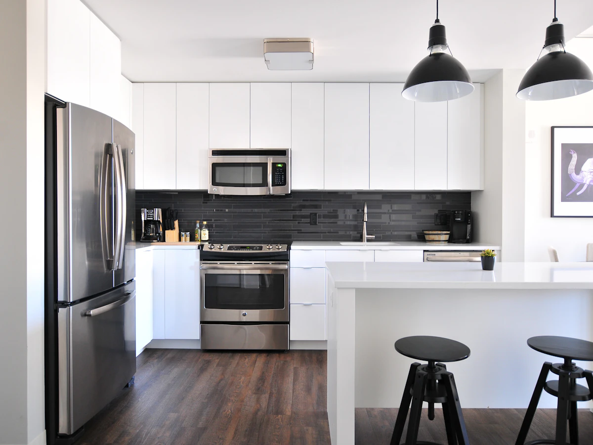 A bright, spotless white kitchen with stainless appliances
